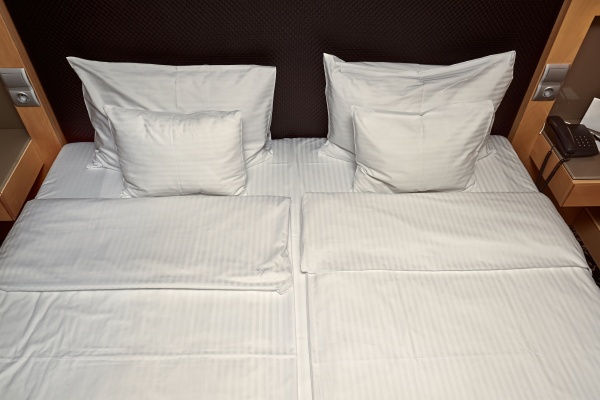 hotel bed with white sheets