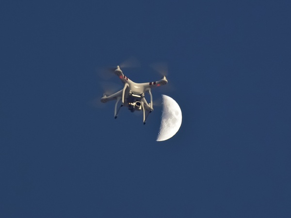 drone against moon and blue sky