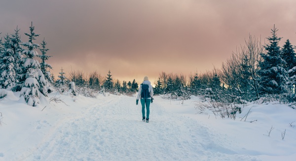 woman hiking through winter landscape during