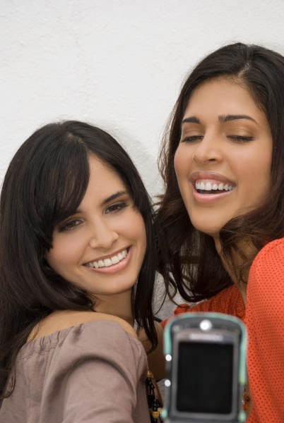 two young women taking a photograph
