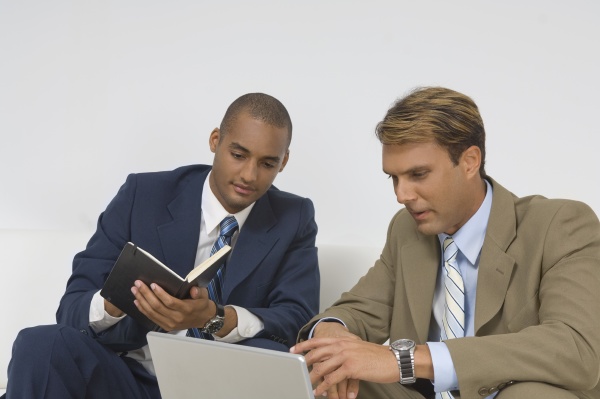 two businessmen looking at a laptop