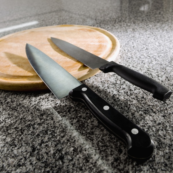 two kitchen knives with a cutting
