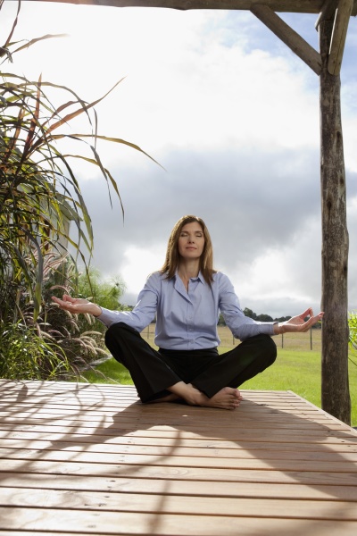 businesswoman meditating in a park