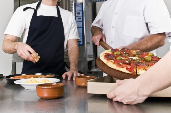 three chefs preparing pizza in the