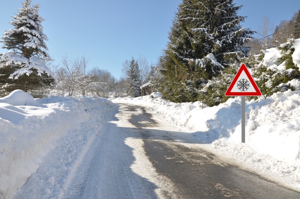 warning sign at snow covered road