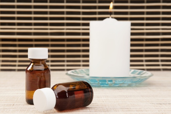 candle with aromatherapy oil bottles