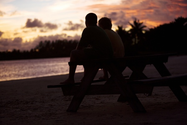 silhouette of two boys sitting on