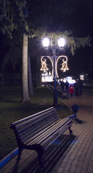 empty bench under lantern in evening
