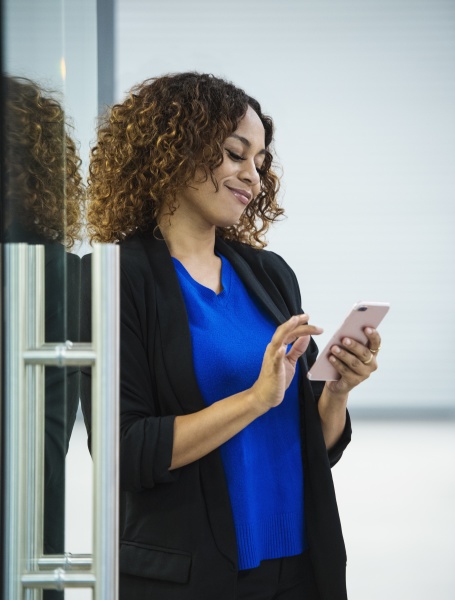 smiling businesswoman using smart phone in