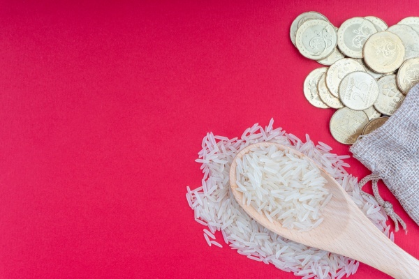coins and rice on red background