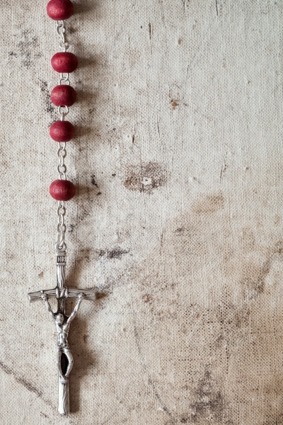 catholic rosary hanging on old canvas