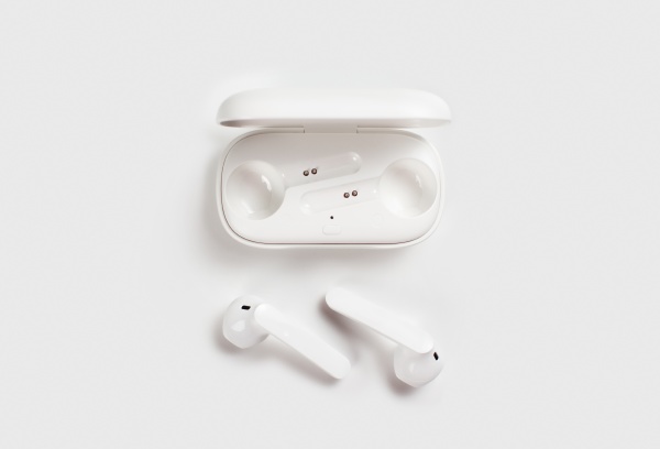 white wireless earphones with case on