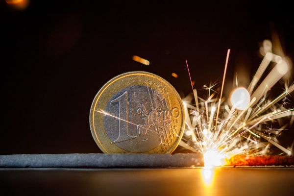 a burning euro coin with fireworks