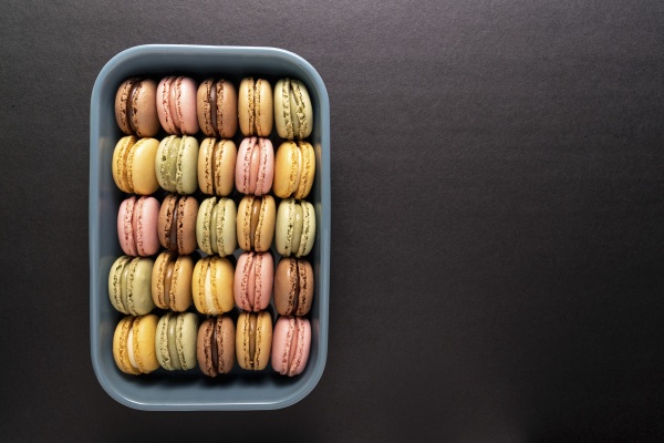 colorful macaroons displayed inside blue container