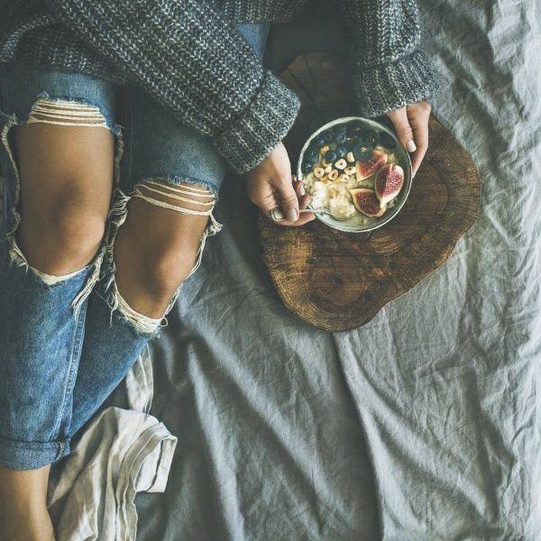 woman in sweater and jeans eating