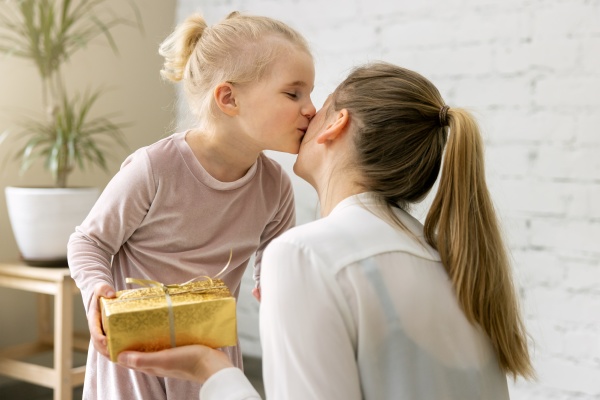 little daughter giving present and kiss