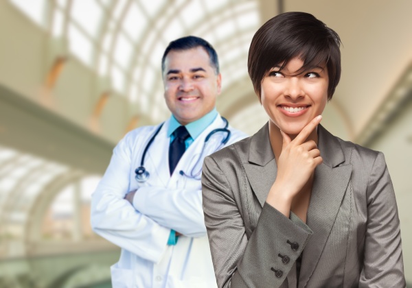 male doctor stands behind woman looking
