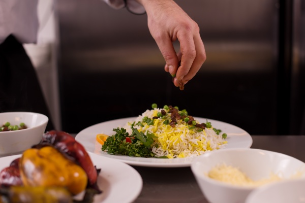 chef hands serving vegetable risotto