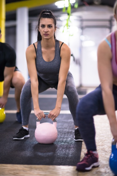 athletes doing exercises with kettlebells
