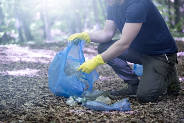 volunteer collecting garbage in the woods