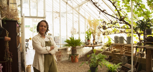 portrait confident female florist in greenhouse
