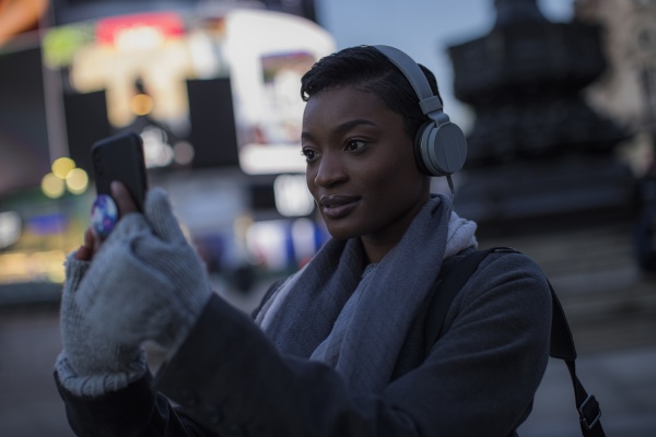 young woman in headphones taking selfie
