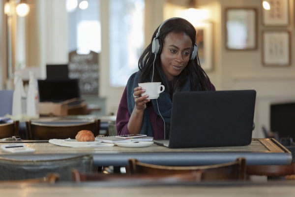 young woman with headphones drinking coffee