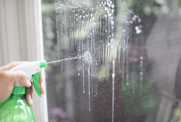 close up cleaning window with spray