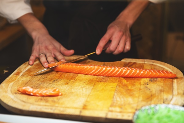 chef cutting salmon fillet