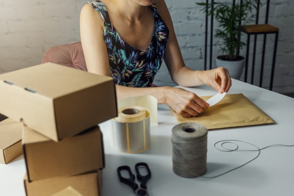 woman preparing parcel shipping label at