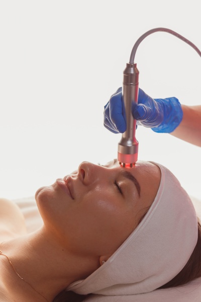 young woman getting microcurrents skin cleansing