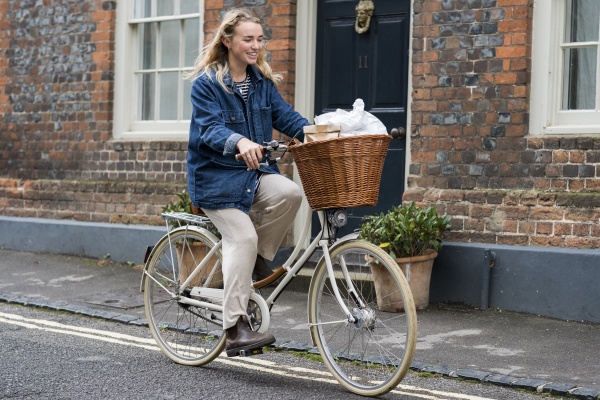 young blond woman cycling down a