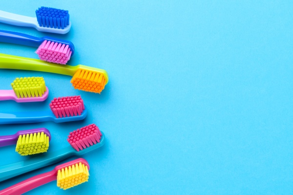 colorful toothbrushes on blue paper background