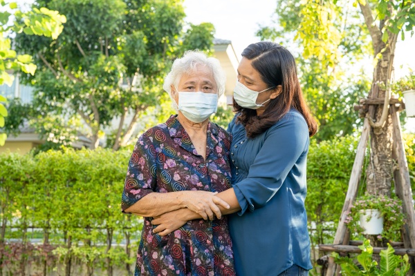 asian elderly woman with caregiver walking