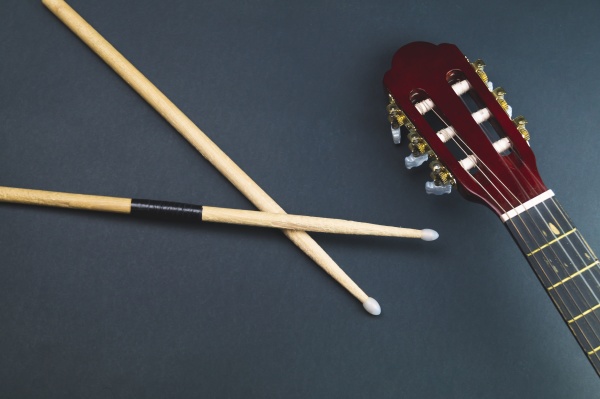 drumsticks and guitar headstock close up