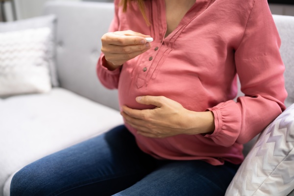 pregnant woman taking vitamin pill