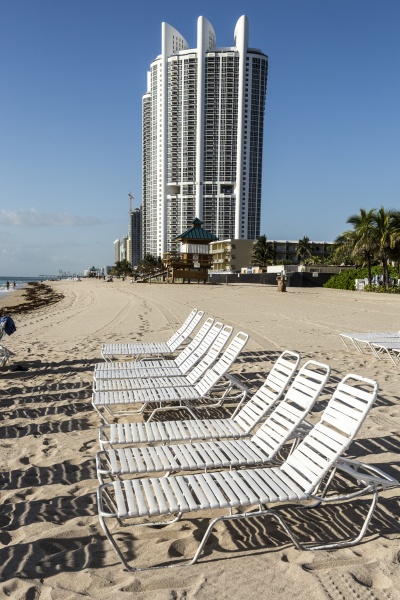 many beach chairs and lounges at