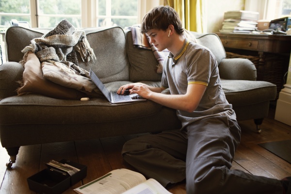 focused teenage boy with laptop studying