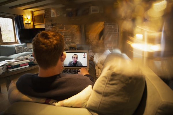 man video conferencing with colleagues on