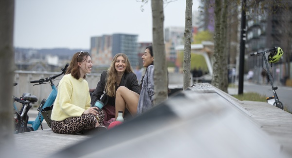 happy young women talking in city
