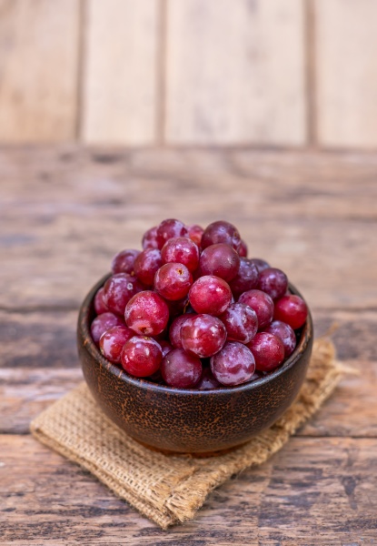 red grape fruit in wooden bowl