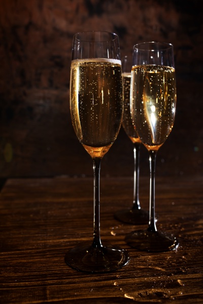 glasses with champagne on dark wood