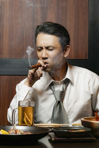 businessman smoking cigar at lunch in