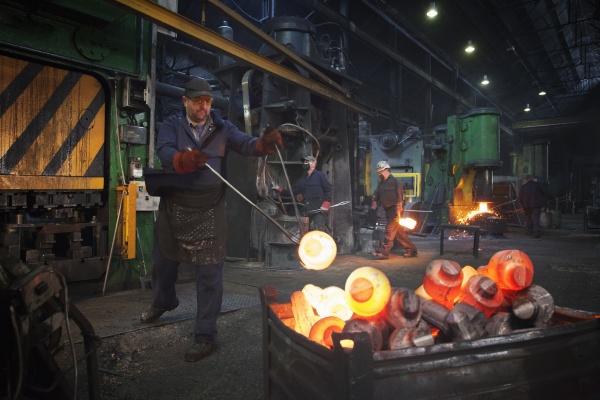 forge worker swings finished forged component