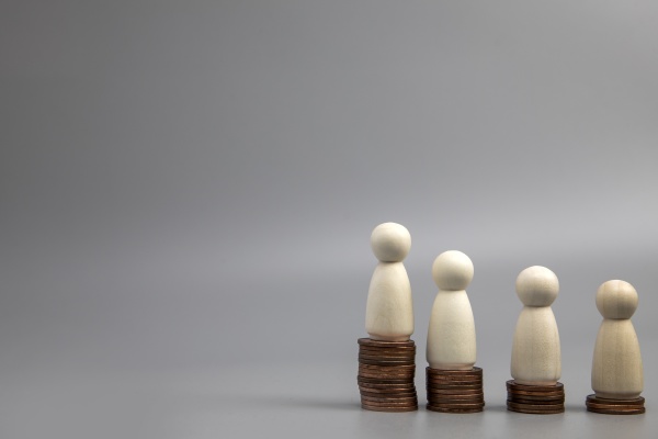 miniature people standing on piles of