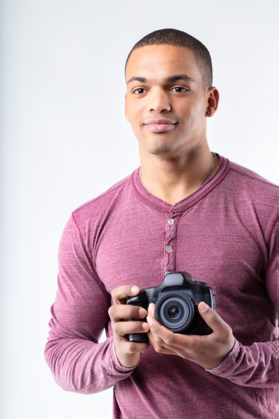 young black photographer standing holding his