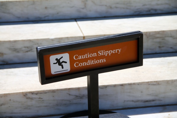 caution slippery conditions brown sign
