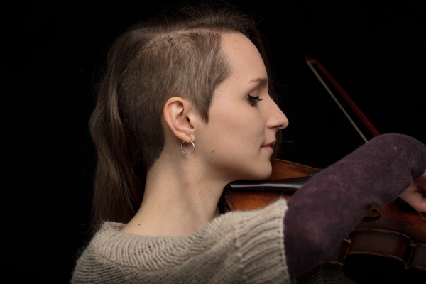 dedicated female violinist playing baroque violin