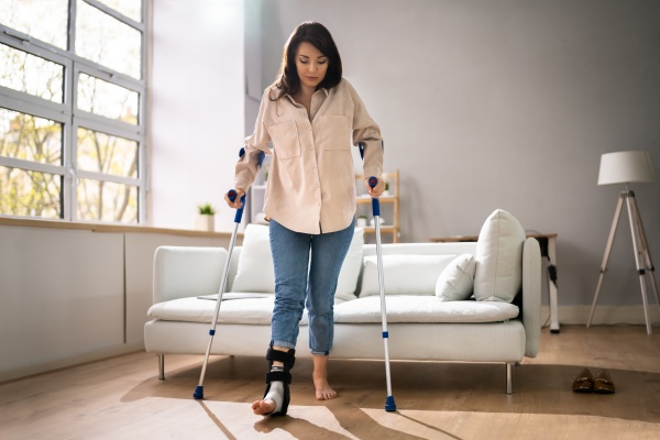 hurt leg using crutches near couch