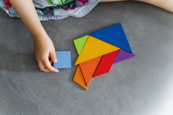 woman playing with multi colored tangram